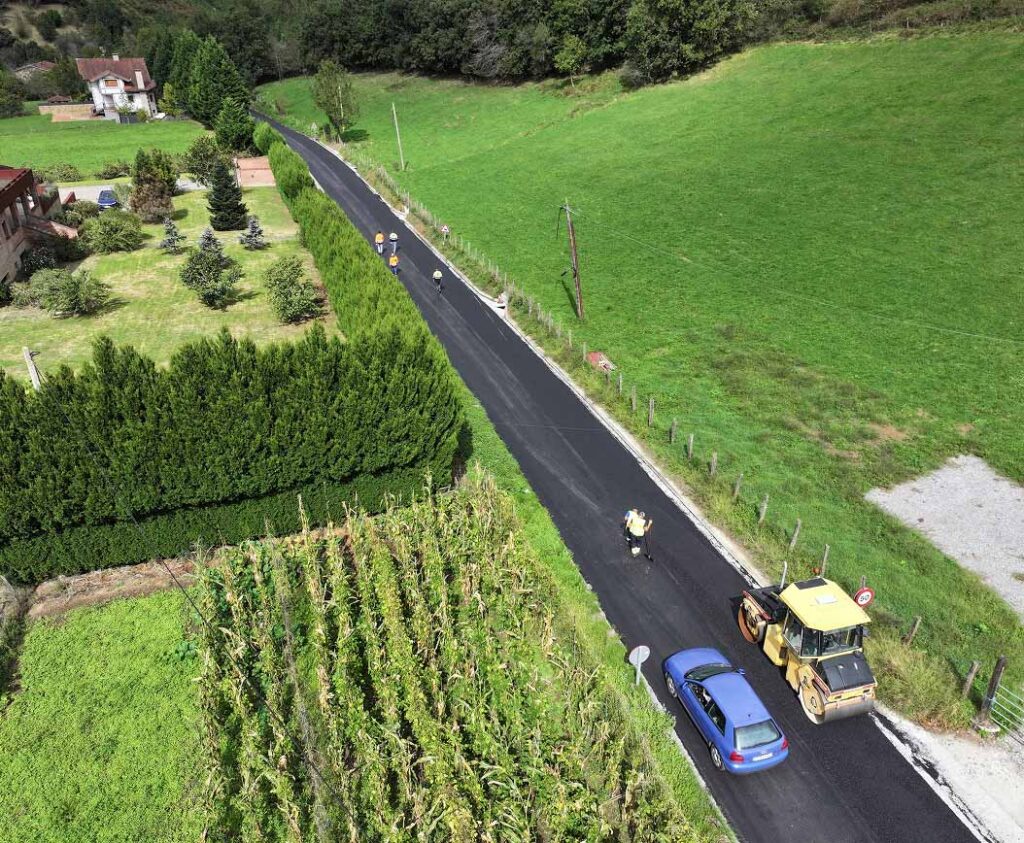 Overhead view of car passing paving vehicle